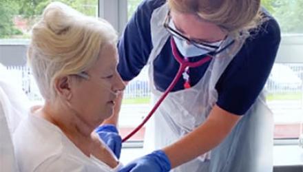 A support worker check a patient's chest